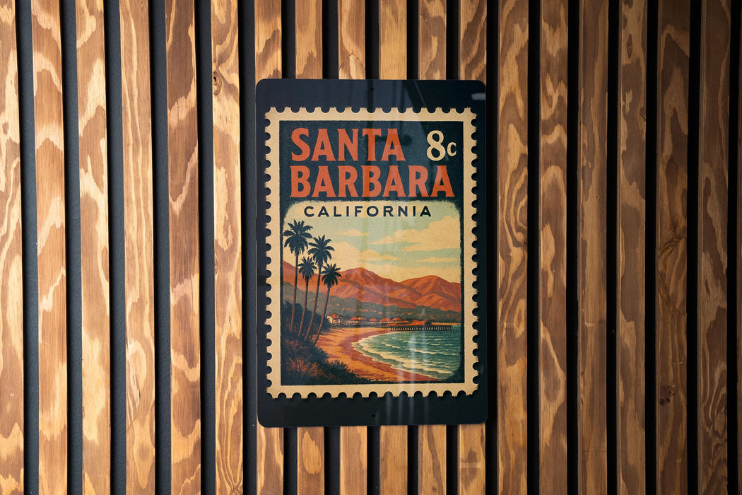 A vintage-style poster of Santa Barbara, California, featuring palm trees and a beach scene, is displayed on a wooden wall.