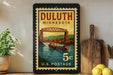 A framed postage stamp from Duluth, Minnesota, depicting a bridge over a river.
