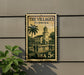 A framed poster of a building with palm trees, depicting a scene from Florida, is displayed on a wall.