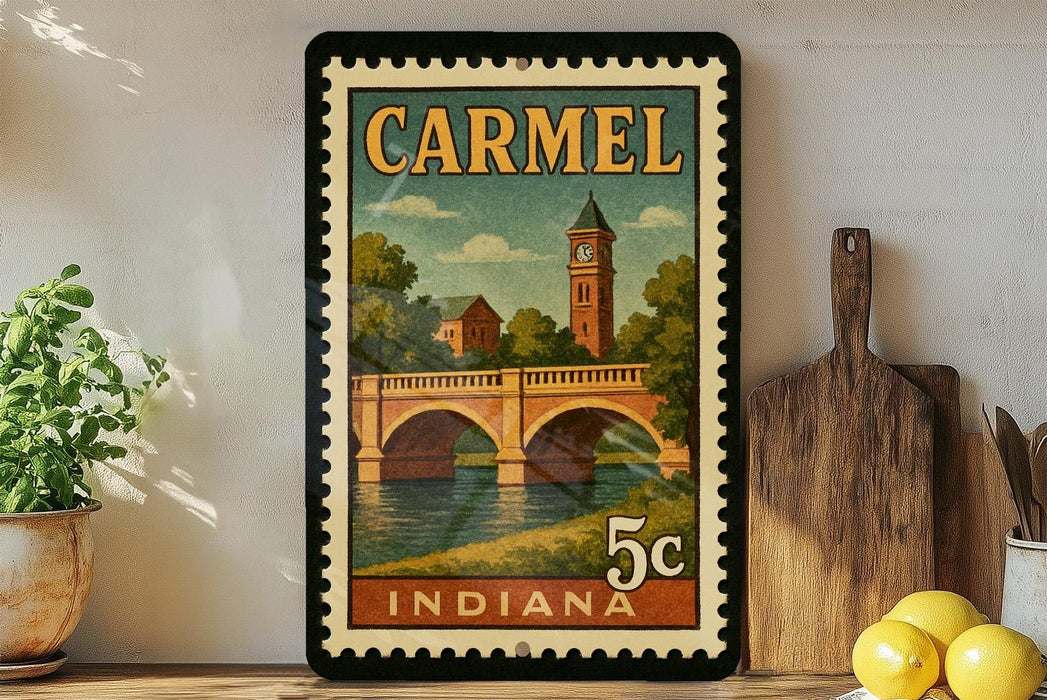A vintage-style postage stamp from Carmel, Indiana, featuring a bridge and a clock tower, displayed on a shelf with kitchen utensils and a potted plant.