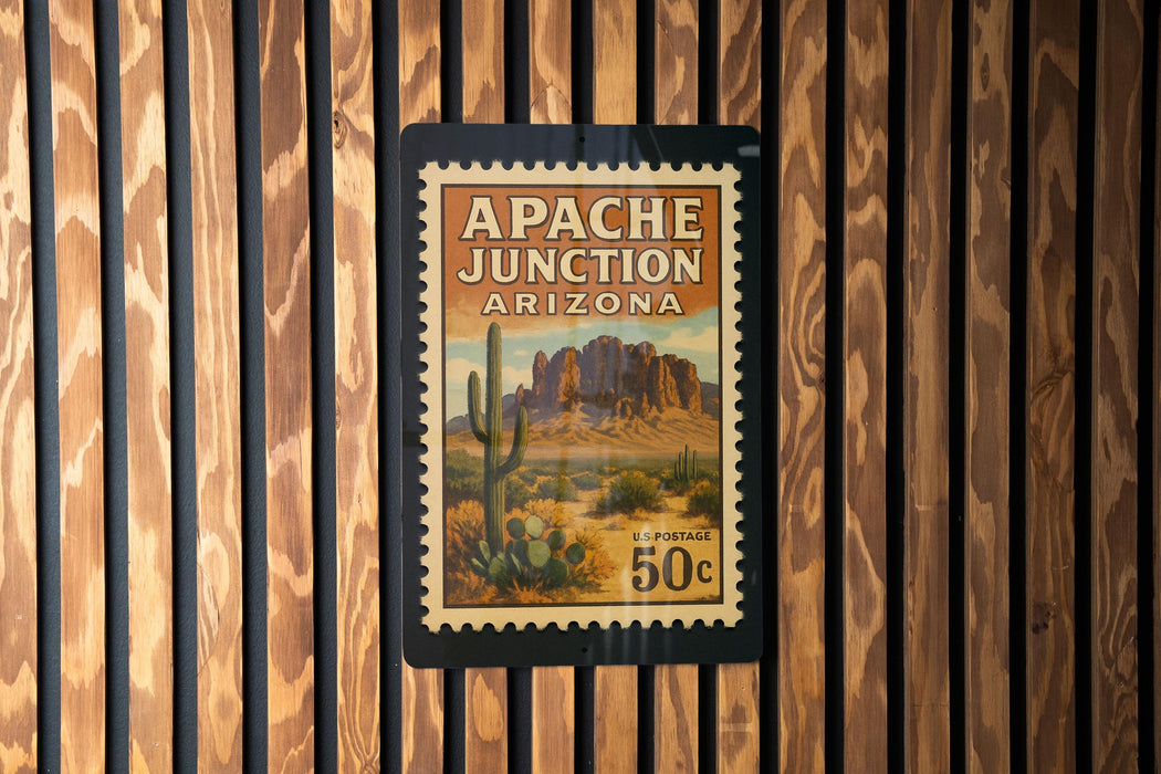 A vintage postage stamp from Arizona, featuring a desert landscape with mountains and cacti, is displayed on a wooden wall.