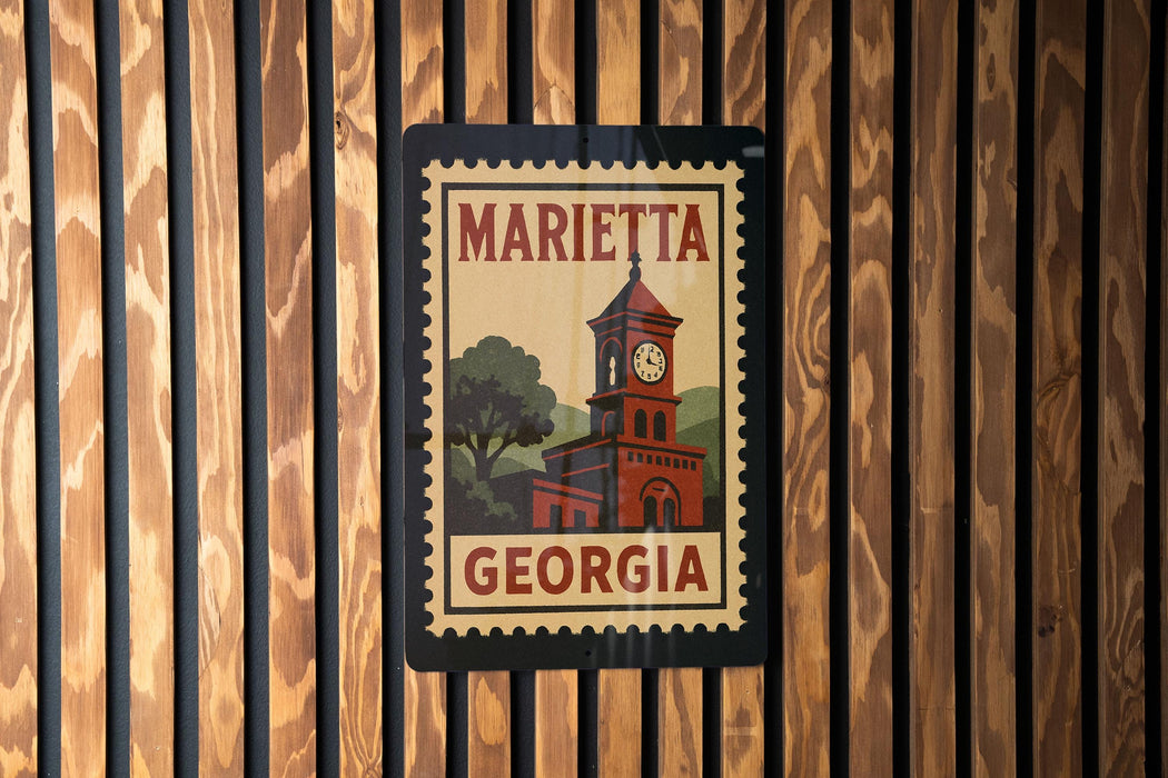 A framed poster of a clock tower with the text "MARIETA GEORGIA" on it, mounted on a wooden wall.