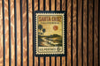 A vintage postage stamp from Santa Cruz, California, featuring a beach scene with palm trees and a sunset.
