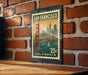 A vintage-style postage stamp from California, featuring the Golden Gate Bridge and the city of San Francisco, is displayed on a brick wall.