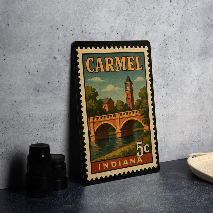 A vintage postage stamp from Indiana featuring a bridge and a clock tower, with the text "CARMEL" and "INDIANA" printed on it.