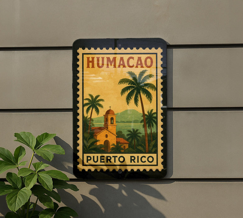 A sign for Humacao, the capital of Puerto Rico, featuring a tropical landscape with palm trees and a church.