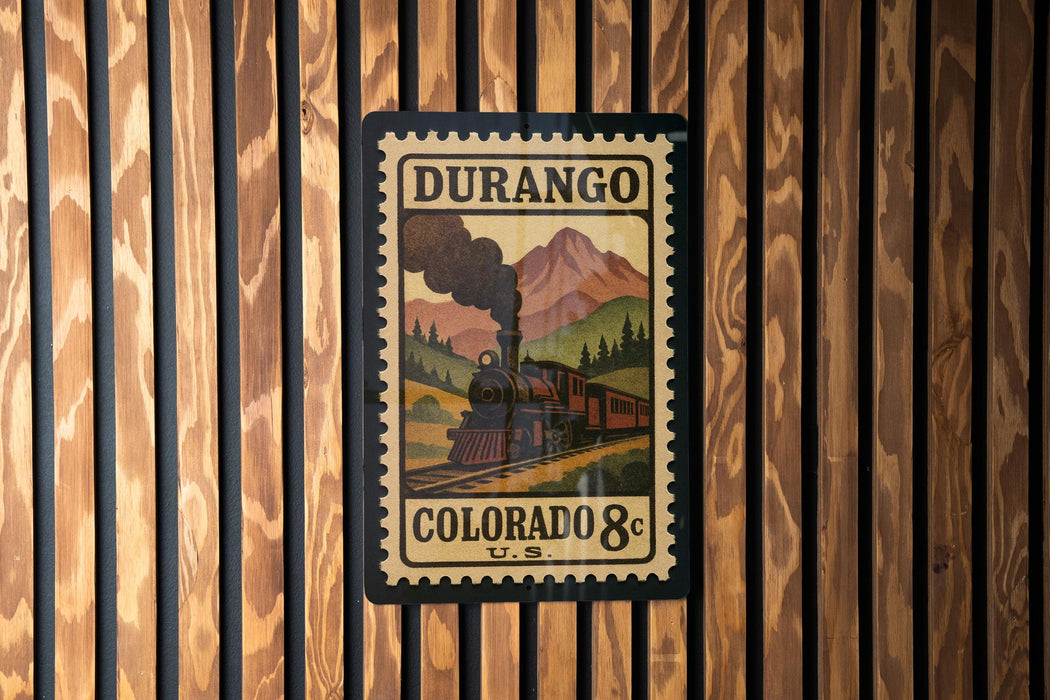 A vintage postage stamp from Durango, Colorado, featuring a steam locomotive on a mountain landscape.