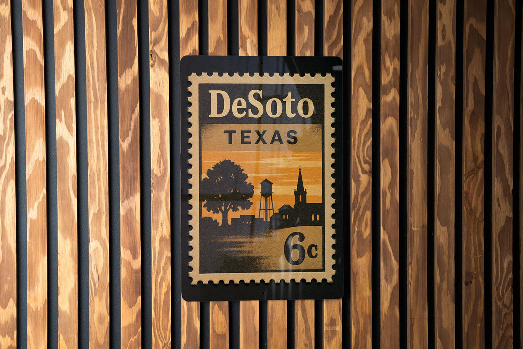 A vintage-style postage stamp from Texas, featuring a silhouette of a town and a tree, mounted on a wooden wall.