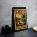 A vintage-style poster of Manati, Puerto Rico, featuring a tropical landscape with palm trees and a house, is displayed on a wall.