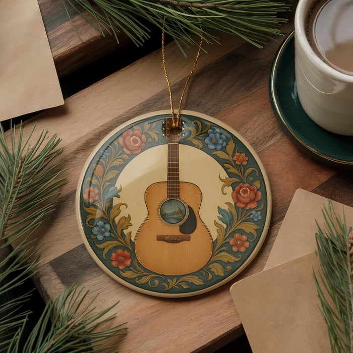 A decorative ornament featuring a guitar is displayed on a wooden surface, surrounded by pine branches and a cup of coffee.