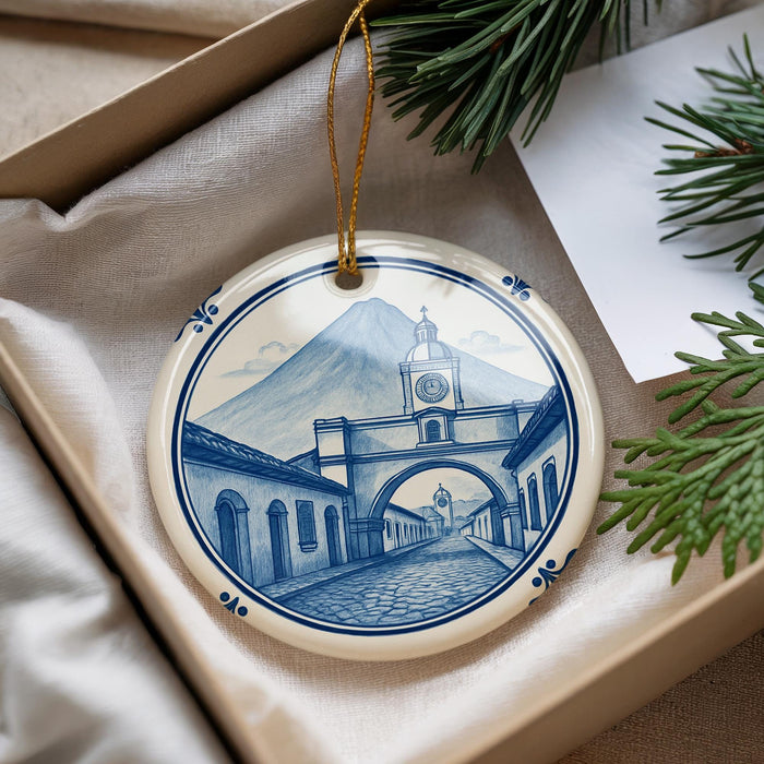 A decorative ornament featuring a blue and white illustration of a street scene with a clock tower, surrounded by greenery.