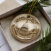 A decorative ornament in a box, featuring an illustration of a building and architectural tools, with the word "ARCHITECT" prominently displayed.