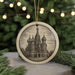 A circular ornament featuring a detailed illustration of the Church of St. Basil's in Moscow, Russia, surrounded by Christmas lights and greenery.