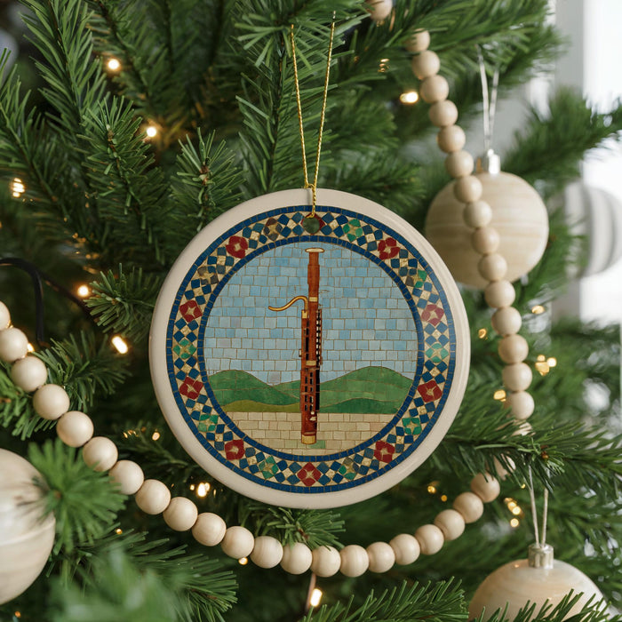 A Christmas tree decorated with ornaments, including a circular ornament featuring a musical instrument and a beaded garland.