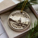 A circular ornament with a drawing of the Bosphorus Strait in Istanbul, Turkey, surrounded by greenery.