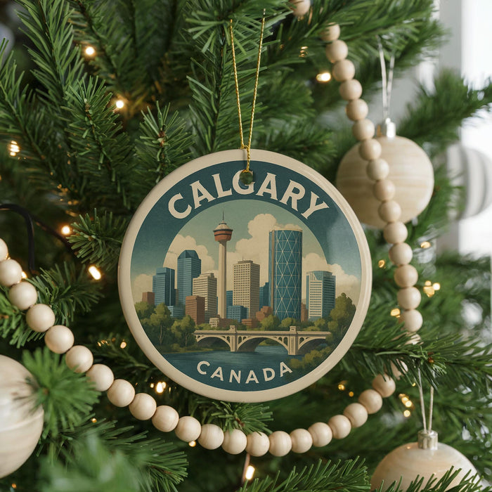 A circular ornament on a Christmas tree, featuring a cityscape of Calgary, Canada, with a bridge and trees in the background.