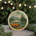 A round ornament featuring an illustration of a van parked on a road near a lake, with mountains in the background.