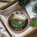 A circular ornament with the text "CATALINA ISLAND U.S.A." and an illustration of a building and boats on a body of water.