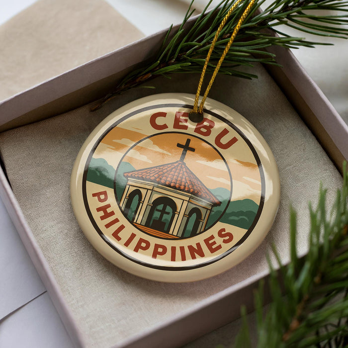 A decorative ornament in a box, featuring a graphic of a building with a cross on top, surrounded by greenery.