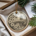 A decorative ornament featuring a Japanese temple and cherry blossom flowers, hanging from a string.