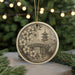 A decorative ornament featuring a Japanese temple and cherry blossom flowers, hanging on a string against a blurred background of Christmas lights.