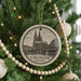 A circular ornament on a Christmas tree, featuring an illustration of the Cologne Cathedral in Germany.