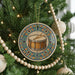 A Christmas tree decorated with ornaments, including a round ornament with a drum and a beaded garland.