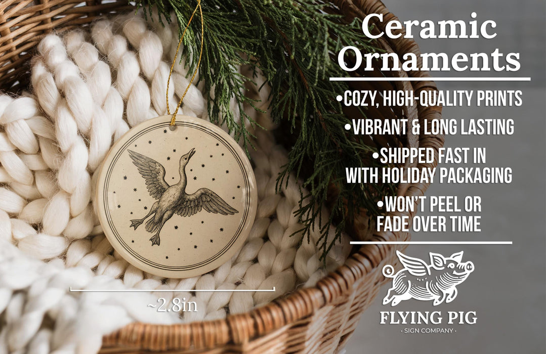 a ceramic ornament hanging from a wicker basket, with a pine branch and greenery in the background.
