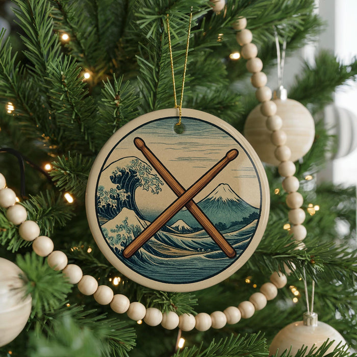 A Christmas tree decorated with ornaments, including a circular ornament with a wave and mountain design, and a wooden bead decoration.
