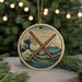 A circular ornament featuring a wave and mountain landscape with a pair of drumsticks crossed in the center.