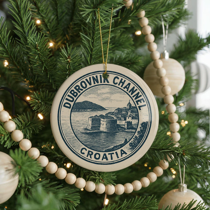 A circular ornament on a Christmas tree, featuring the text "DUBROVNIK CHANNEL CROATIA" and an illustration of a castle or fort.
