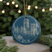 A blue ornament with a white illustration of a castle or cathedral, featuring the word "DUR" in the center.