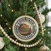 A circular ornament on a Christmas tree, featuring the image of Edinburgh Castle in Scotland.