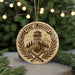 A round ornament with a design featuring a fire lookout tower, crossed shovels, and a wreath, with the text "FIRE LOOKOUT" on it.