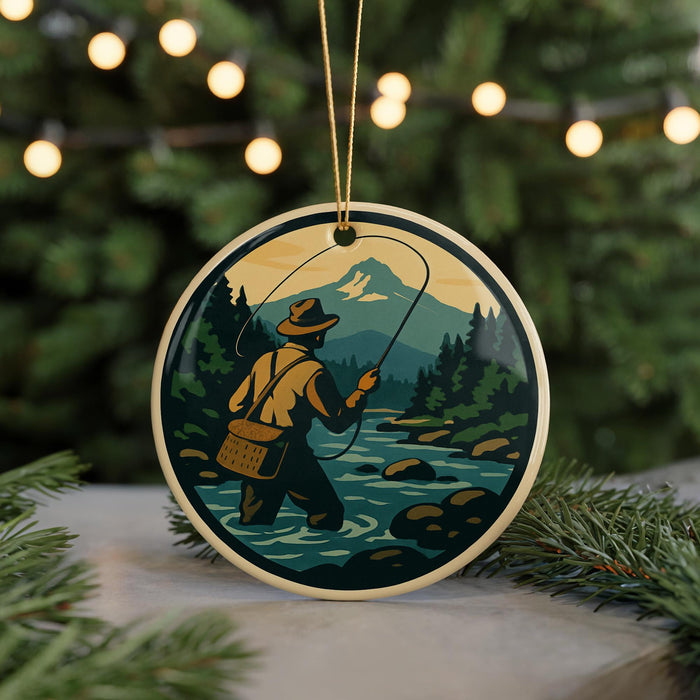 A round ornament depicting a person fishing in a river, with a mountainous landscape in the background.