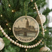 A circular ornament on a Christmas tree, featuring an illustration of the Brandenburg Bridge in Frankfurt, Germany.