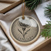 A decorative ornament in a box, featuring a detailed illustration of a flower and the word "JANUARY" written on it.