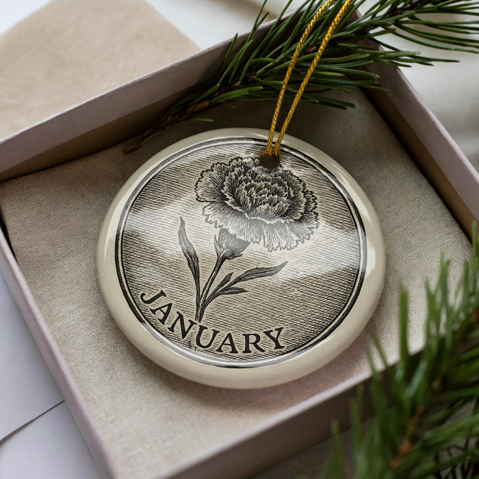 A decorative ornament in a box, featuring a detailed illustration of a flower and the word "JANUARY" written on it.