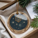 A decorative ornament with a starry night sky design and the word "PLEIADES" on it, hanging from a string.