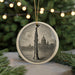 A round ornament featuring a saxophone and a city skyline, with a string of lights in the background.