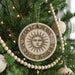 A Christmas tree decorated with ornaments, including a sun-themed ornament with a sun design.