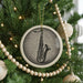 A Christmas tree decorated with ornaments, including a large circular ornament featuring a saxophone design.