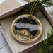 A decorative ornament in a box, featuring a starry night sky and a lighthouse, with the text "The Little Dipper" on it.
