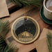 a decorative ornament with a starry night sky design, hanging on a wooden surface.
