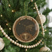 A Christmas tree decorated with ornaments, including a circular ornament with a bear and a starry night sky design.