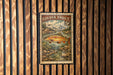 A framed image of a golden trout, a type of fish, is displayed on a wooden wall.