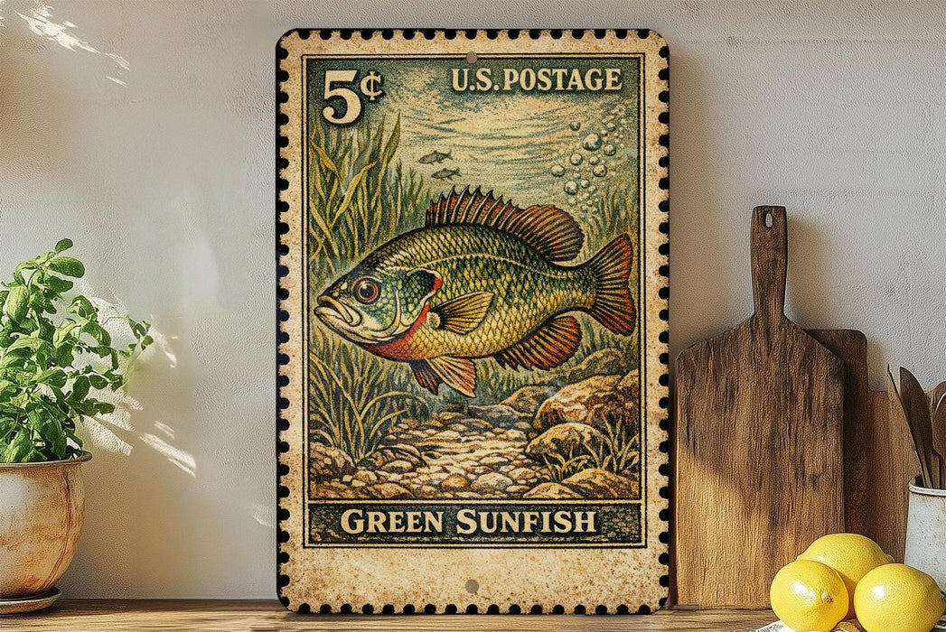 A vintage U.S. postage stamp featuring a green sunfish, placed on a wooden surface next to a wooden cutting board and a potted plant.