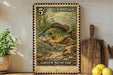 A vintage U.S. postage stamp featuring a green sunfish, placed on a wooden surface next to a wooden cutting board and a potted plant.