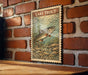 A vintage-style stamp depicting a lake trout is displayed on a brick wall.