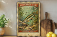 A vintage-style postage stamp featuring a fish, likely a lepsosteus, swimming in a green underwater scene. The stamp is displayed on a wall, with a wooden cutting board and a potted plant visible in the foreground.